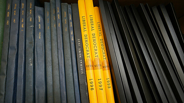 A shelf of books, some showing the words 'Liberal Democrats' and years on their spines