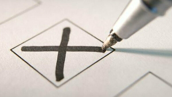 A pen marking an X vote in a box