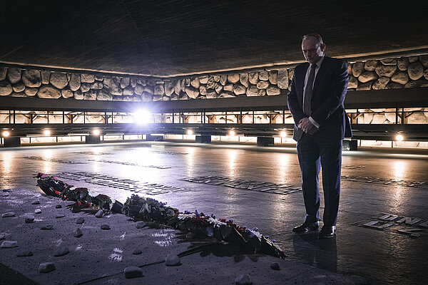 Ed Davey stands with his hands clasped in front of his body having lain a wreath at Yad Vashem, the Holocaust Memorial