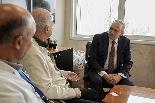 Ed Davey listens to two men at the Makassed Hospital in East Jerusalem