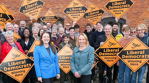 Sarah Green and Helen Morgan in front of a crowd holding Liberal Democrat posters