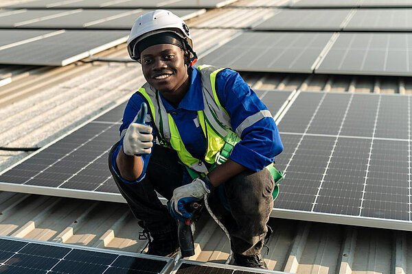 A man putting solar panels on a roof.