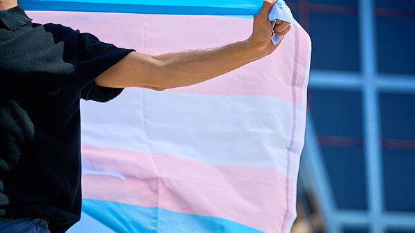Someone holding a trans rights flag