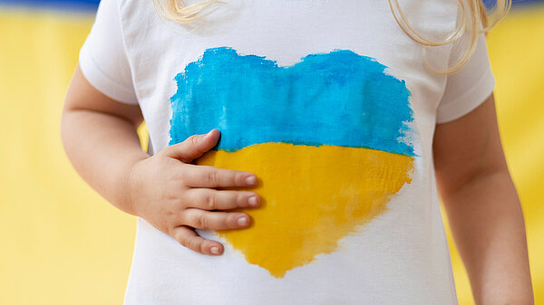 child wearing a t-shirt with Ukranian flag in a heart shape