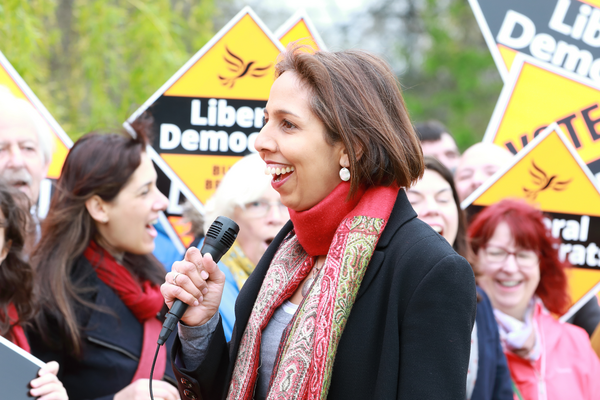 Munira Wilson in front of a crowd holding diamond posters