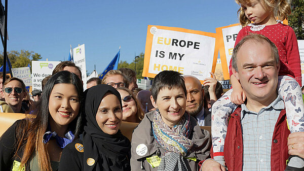 Ed Davey and Caroline Pidgeon with a group and a sign showing 'Europe is my home'