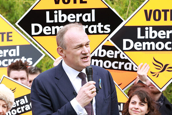 Ed Davey in front of a crowd of people holding Liberal Democrat posters