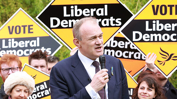 Ed Davey in front of a crowd holding Liberal Democrat posters