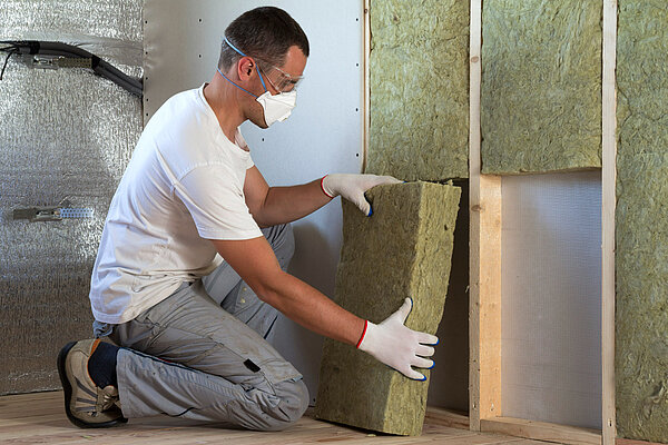A man fitting home insulation