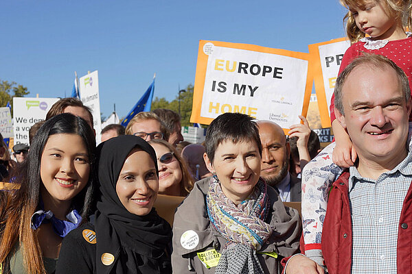 Ed Davey and Caroline Pidgeon with a group and a sign showing 'Europe is my home'