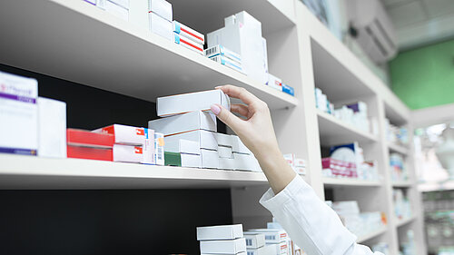 A pharmacist reaching for a box of medication