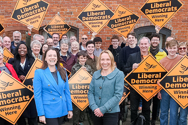 Sarah Green and Helen Morgan in front of a crowd holding Liberal Democrat posters