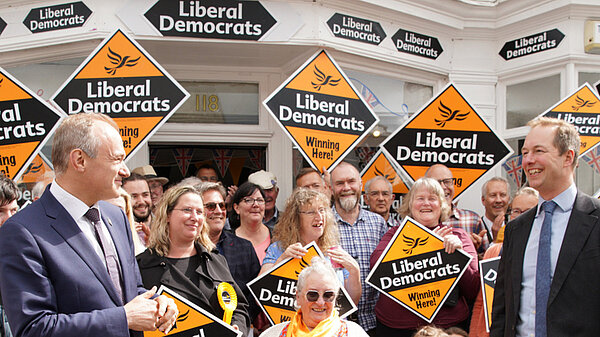 Ed Davey and Richard Foord in front of a crowd holding Liberal Democrat posters