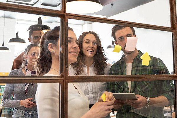 Five people looking a board with post-it notes