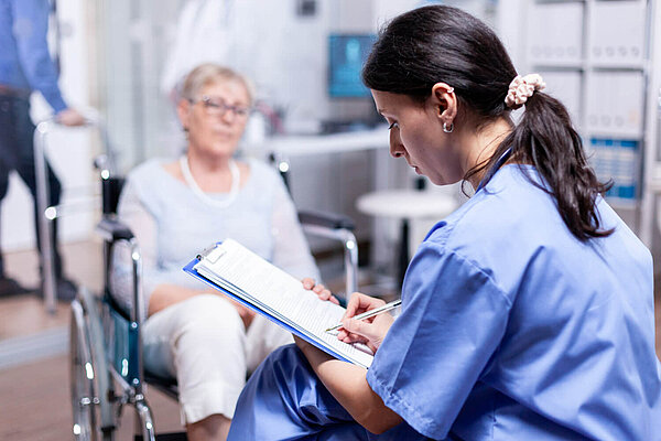 Doctor and patient A doctor writes on a clipboard while a patient waits